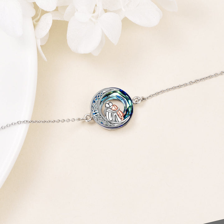 Silver bracelet with a round, engraved design on a light background
