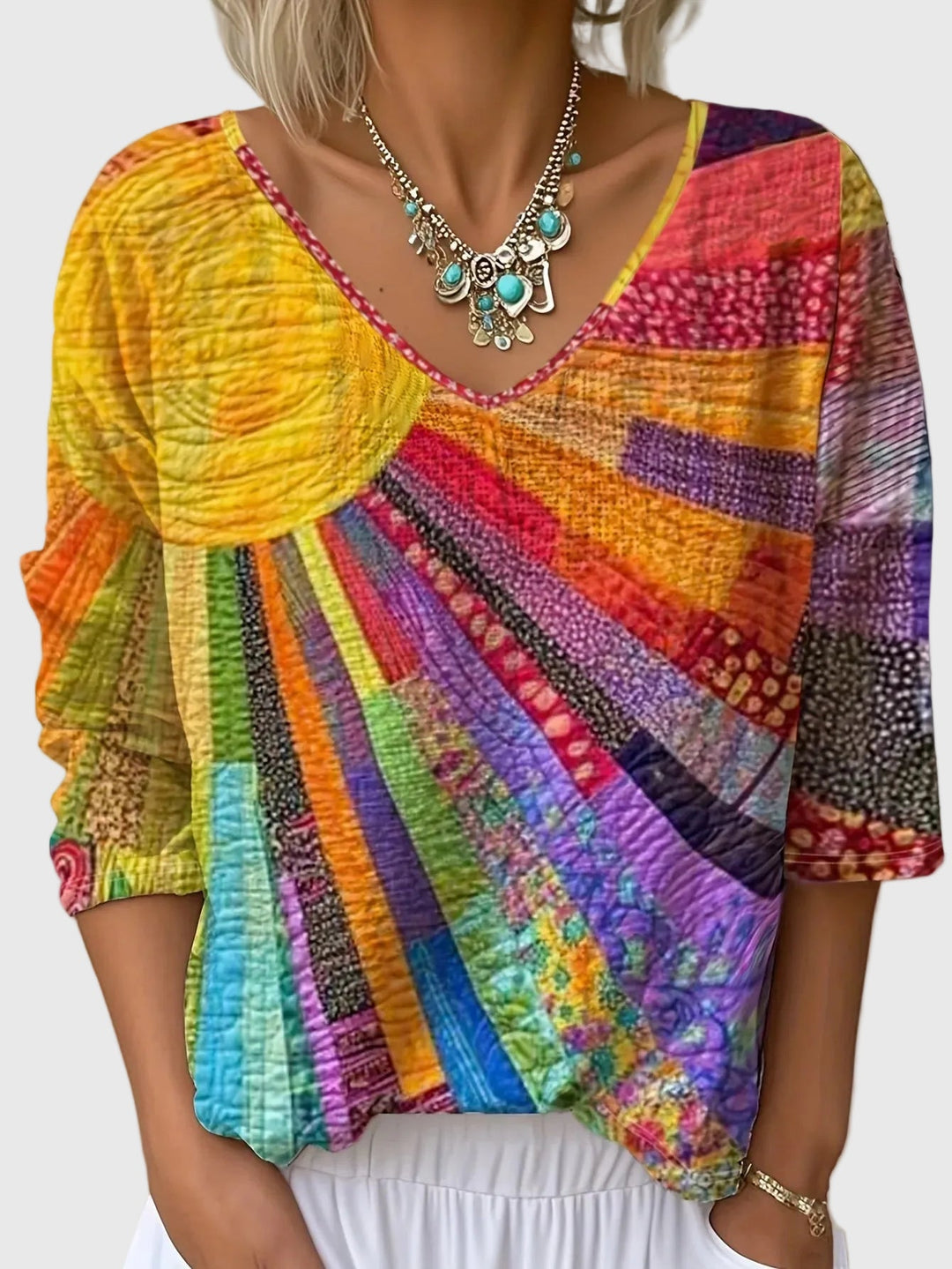 Colorful patterned top worn by a person on a plain background