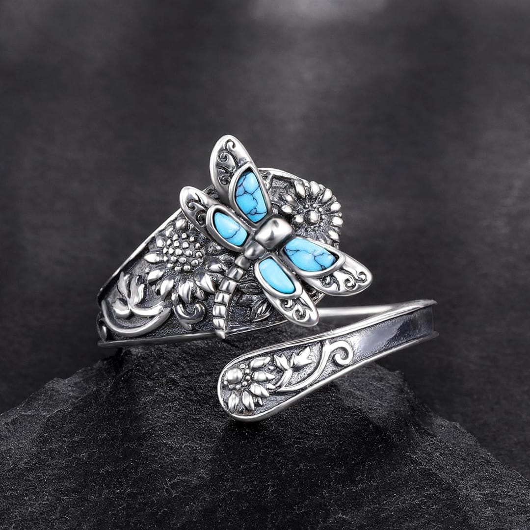 Silver ring with blue gemstone butterfly design on a dark background