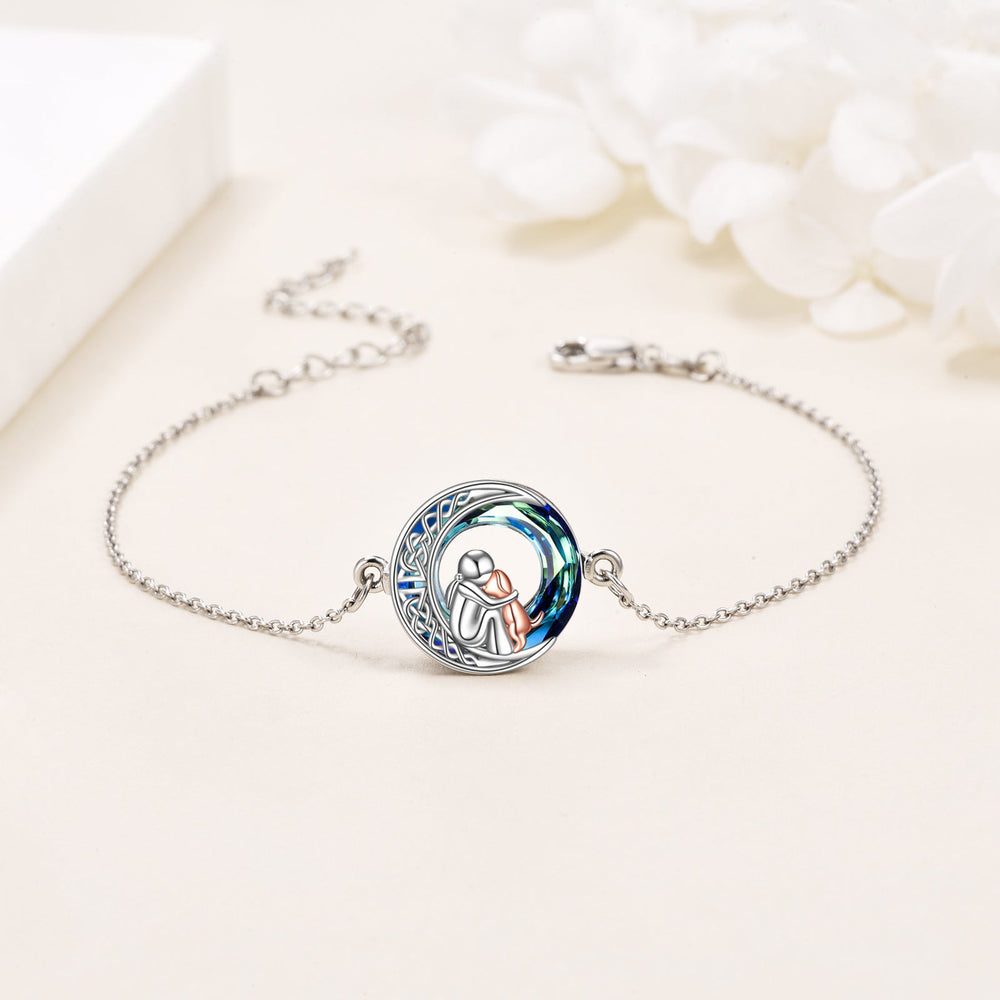 Silver bracelet with a circular charm featuring an illustration of a couple, on a light background.