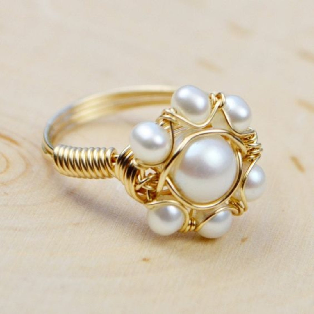Gold ring with pearls on a wooden surface
