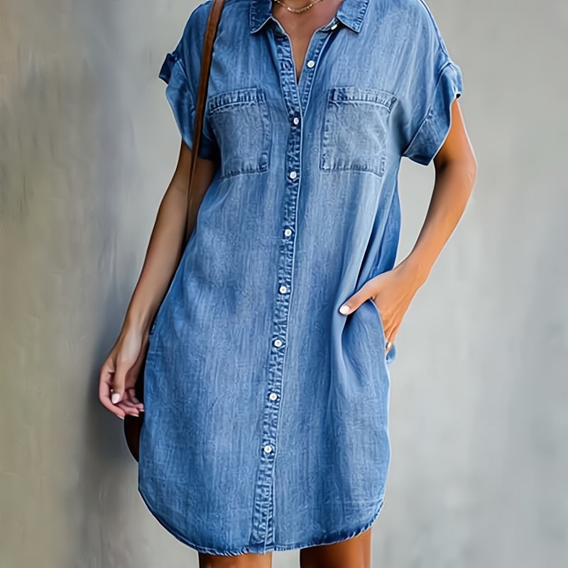 Person wearing a blue denim dress against a plain background