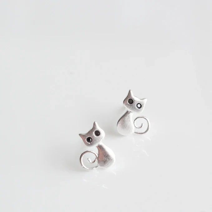 Silver cat-shaped earrings on a light gray background