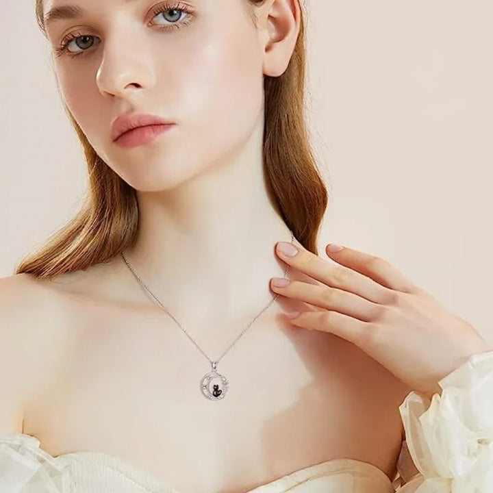 Woman wearing a silver necklace with a round pendant on a beige background