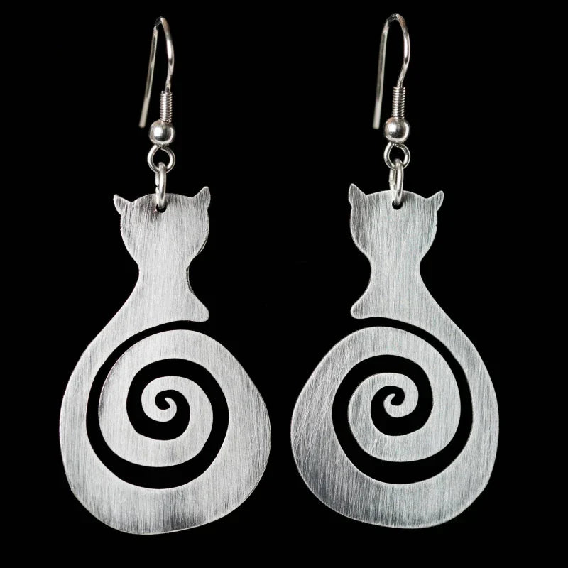 Cat-shaped earrings with spiral design on a black background