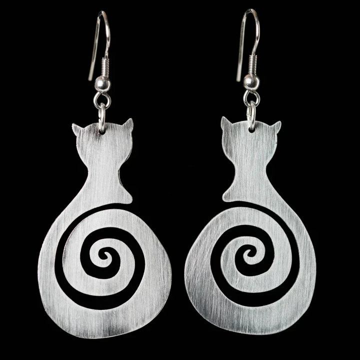 Cat-shaped earrings with spiral design on a black background