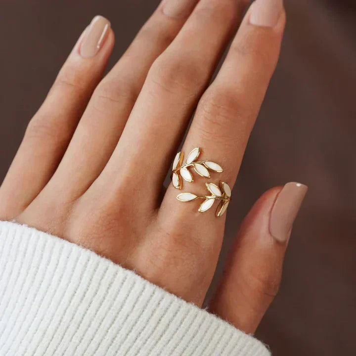 Gold leaf ring on a hand with a blurred background