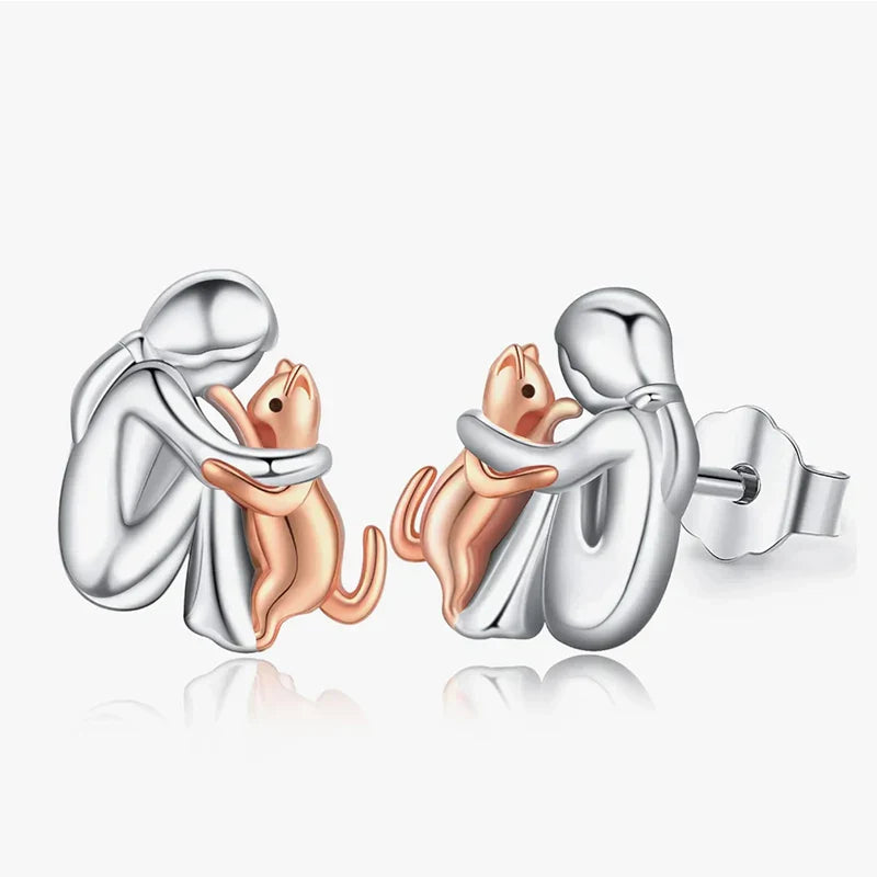 Pair of silver and rose gold cat-shaped earrings on a white background