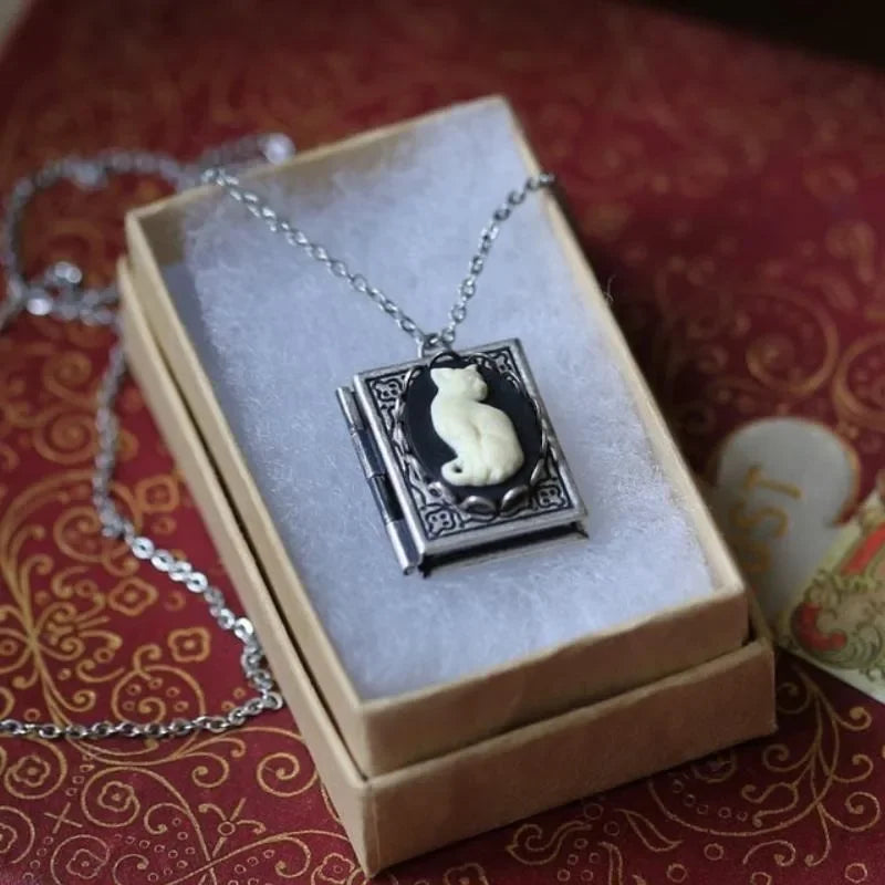 Necklace with a cat pendant in a decorative box on a red patterned fabric background