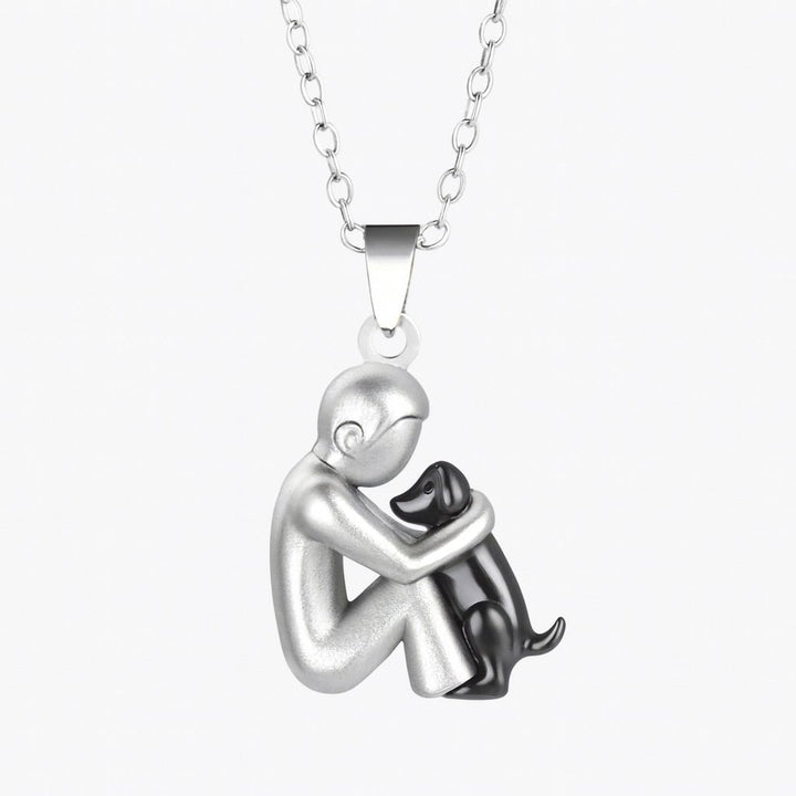 Silver pendant necklace with a figure hugging a black figure on a white background
