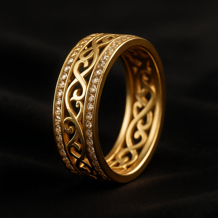 Gold ring with intricate design on a dark background