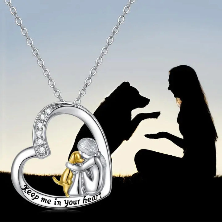 Heart-shaped pendant with a dog and person design, featuring the text &