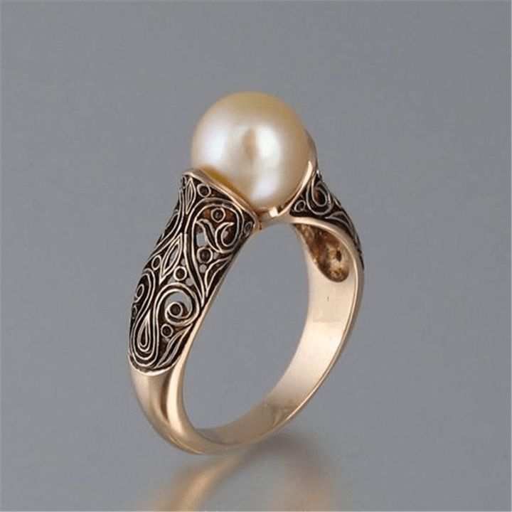 Gold ring with a pearl on a gray background