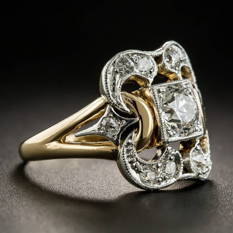 Gold and silver ring with diamond accents on a dark background