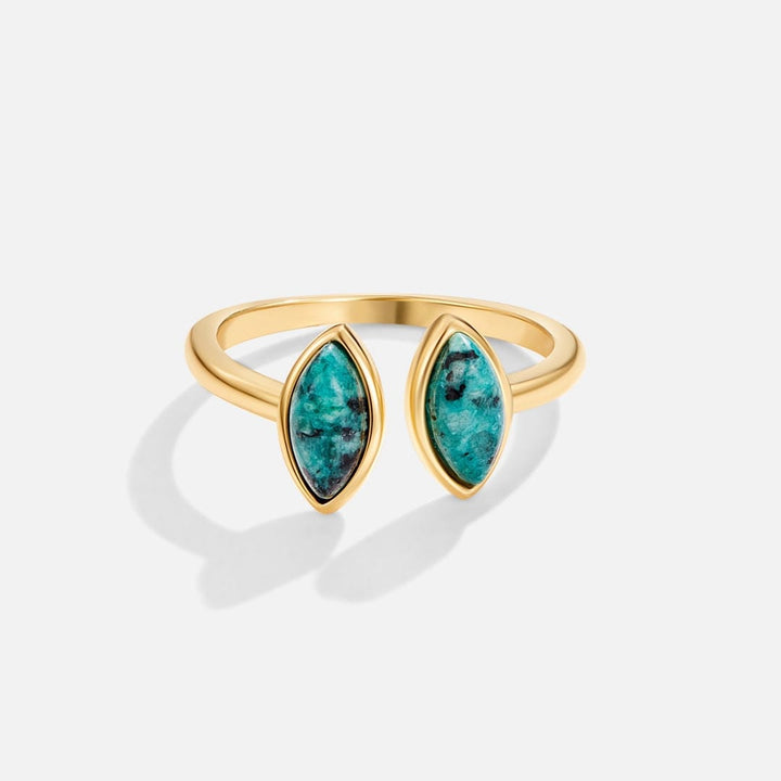Gold ring with turquoise stones on a white background