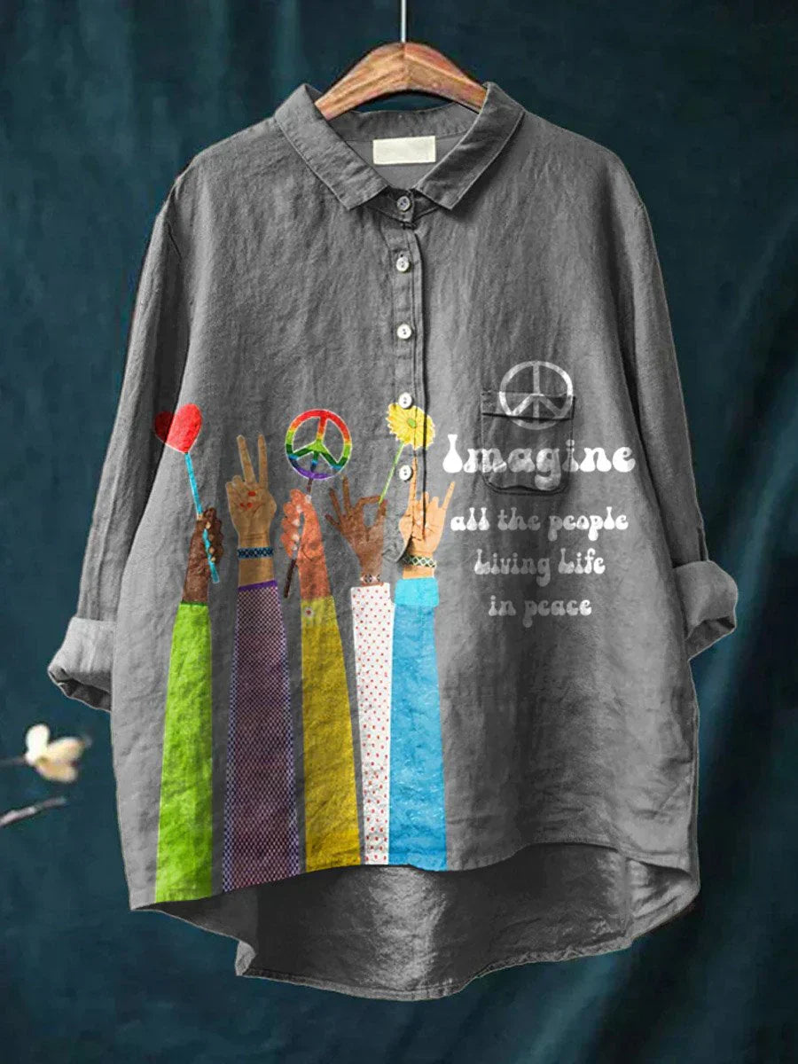 Gray shirt with peace sign and hand gestures design on a hanger against a dark background