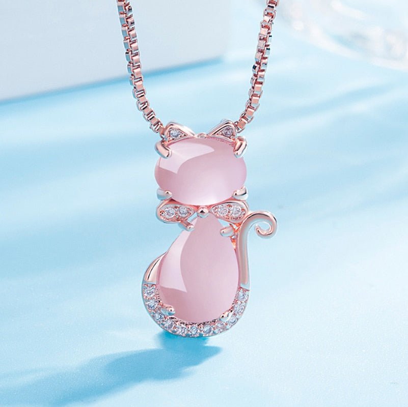 Pink cat-shaped pendant necklace on a light blue background