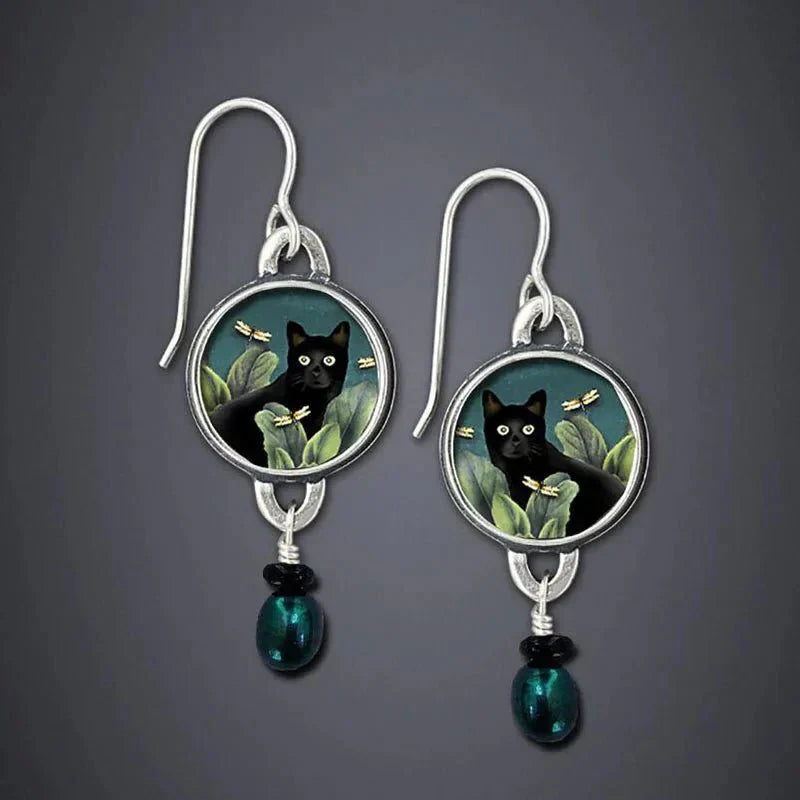 Pair of earrings with black cat design on a gray background