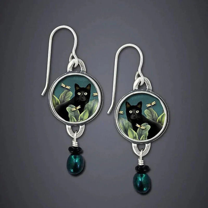 Pair of earrings with black cat design on a gray background