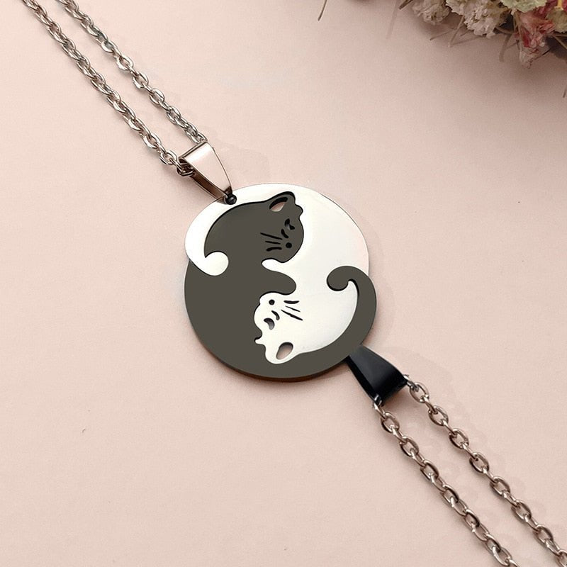 Necklace with a yin yang design featuring two cats on a beige background