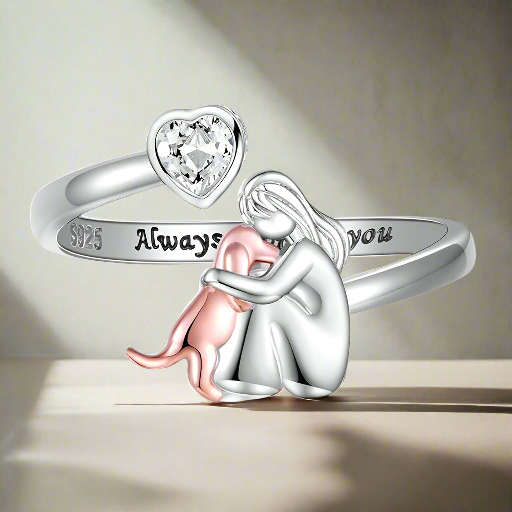 Silver ring with heart-shaped gem and 'Always' engraving, featuring a small figure holding a rose.